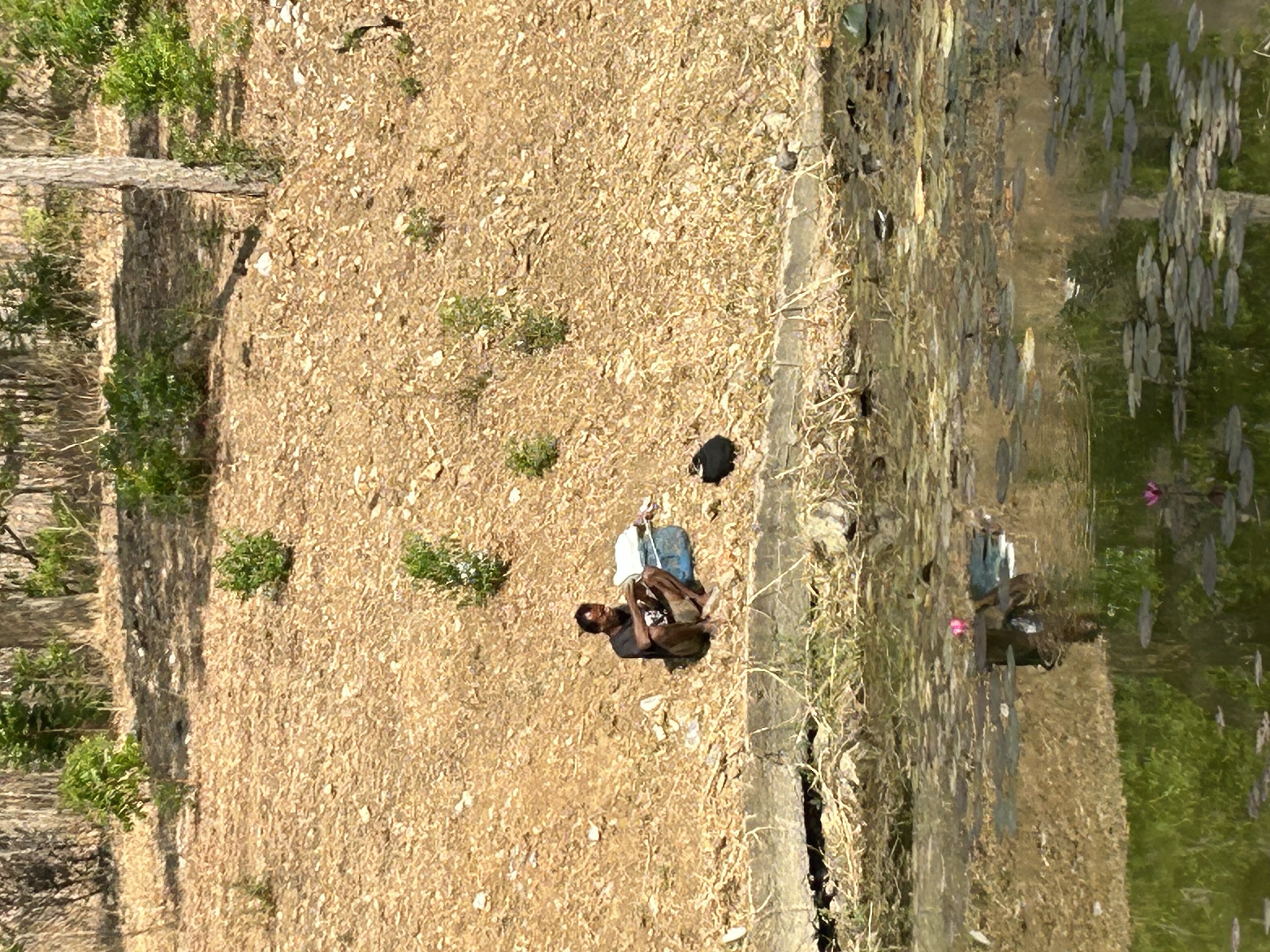 Un pêcheur à la ligne au bord d'un des nombreux obstacles d'eau.